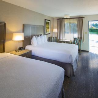 Best Western Plus Hilltop Inn | Redding, California | Two queen beds with white sheets, work desk, seating area, and view of outside from door
