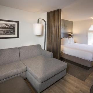 Best Western Plus Hilltop Inn | Redding, California | Grey sofa sleeper couch and king bed split up with partition
