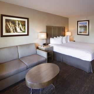 Best Western Plus Hilltop Inn | Redding, California | King bed with white sheets and grey sofa sleeper